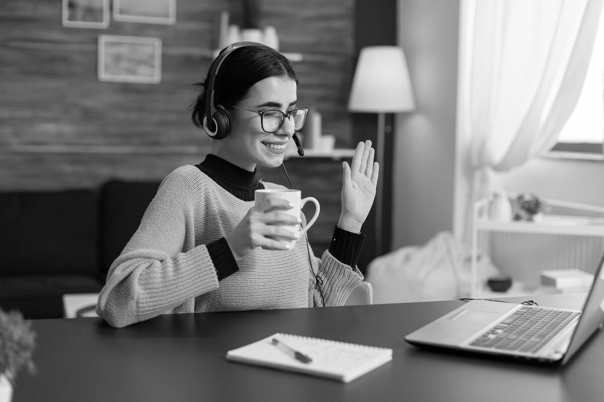 Studierende winkt freudig in einem Videoanruf – symbolisiert das Online-Format der Coffee Lecture